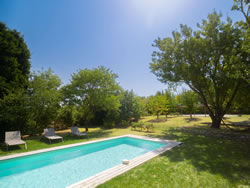 Heated swimming pool and sun loungers in the tranquil landscape of Southern France