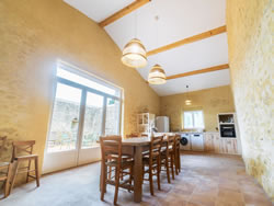 Modernized kitchen and large dining table in a historic setting for guest use