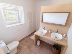 Private en-suite bathroom with double vanity and modern amenities in the Passeron room