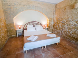 High-end King-size bed set under a historic stone arch in our boutique B&B