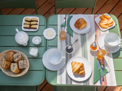 Full French breakfast with pastries and fresh fruit served on the terrace in the Lauragais region