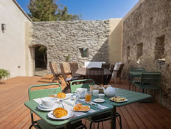 Convivial breakfast on the wooden terrace surrounded by historic dry stone walls