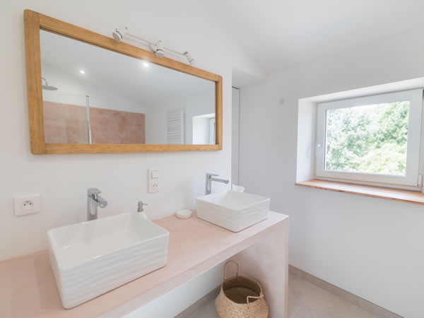 Private bathroom of the Pastoreta suite featuring a bathtub-shower combo and a double vanity